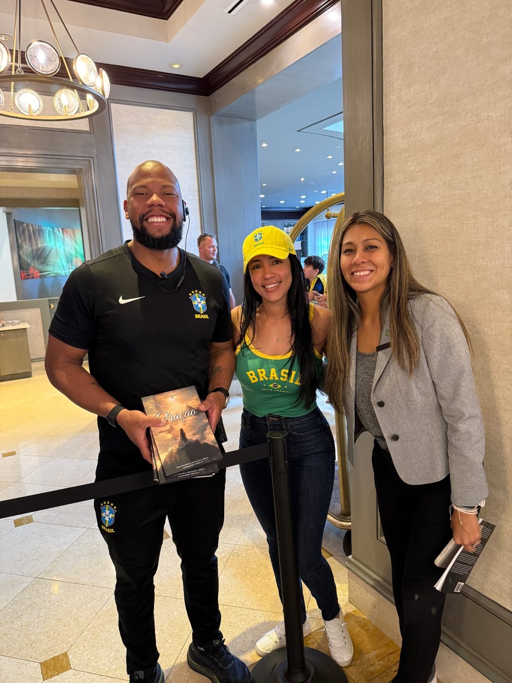 Stefania Leão hands wrapped copies of Oração to a member of Brazil's national-team delegation in the team hotel lobby during the World Cup